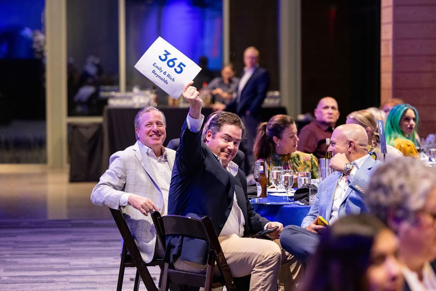 Guests raising a bid paddle at the Greater Heights Night gala