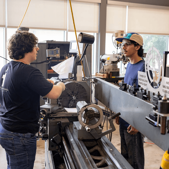 An Alamo Heights teacher working with a student in a district shop class