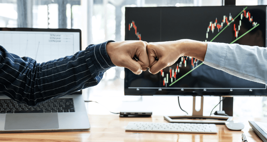 Two business owners shaking hands over a share transfer