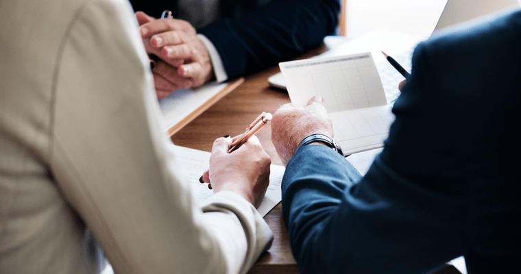 An advisor and client signing trust paperwork