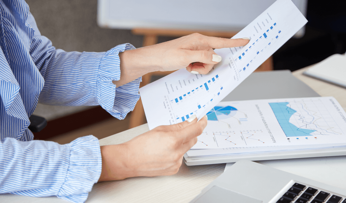 Hands reviewing a printed financial report at a desk